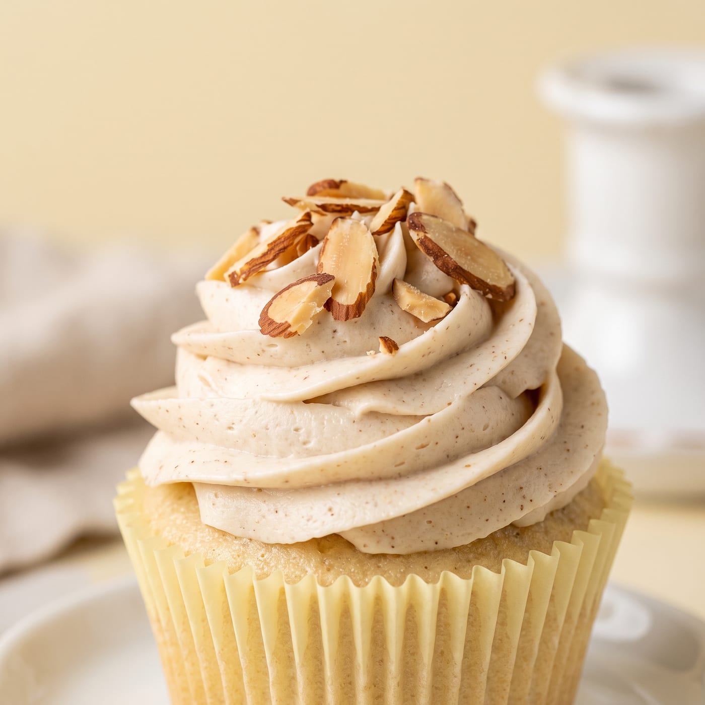 Close up of almond buttercream swirl topped with toasted sliced almonds