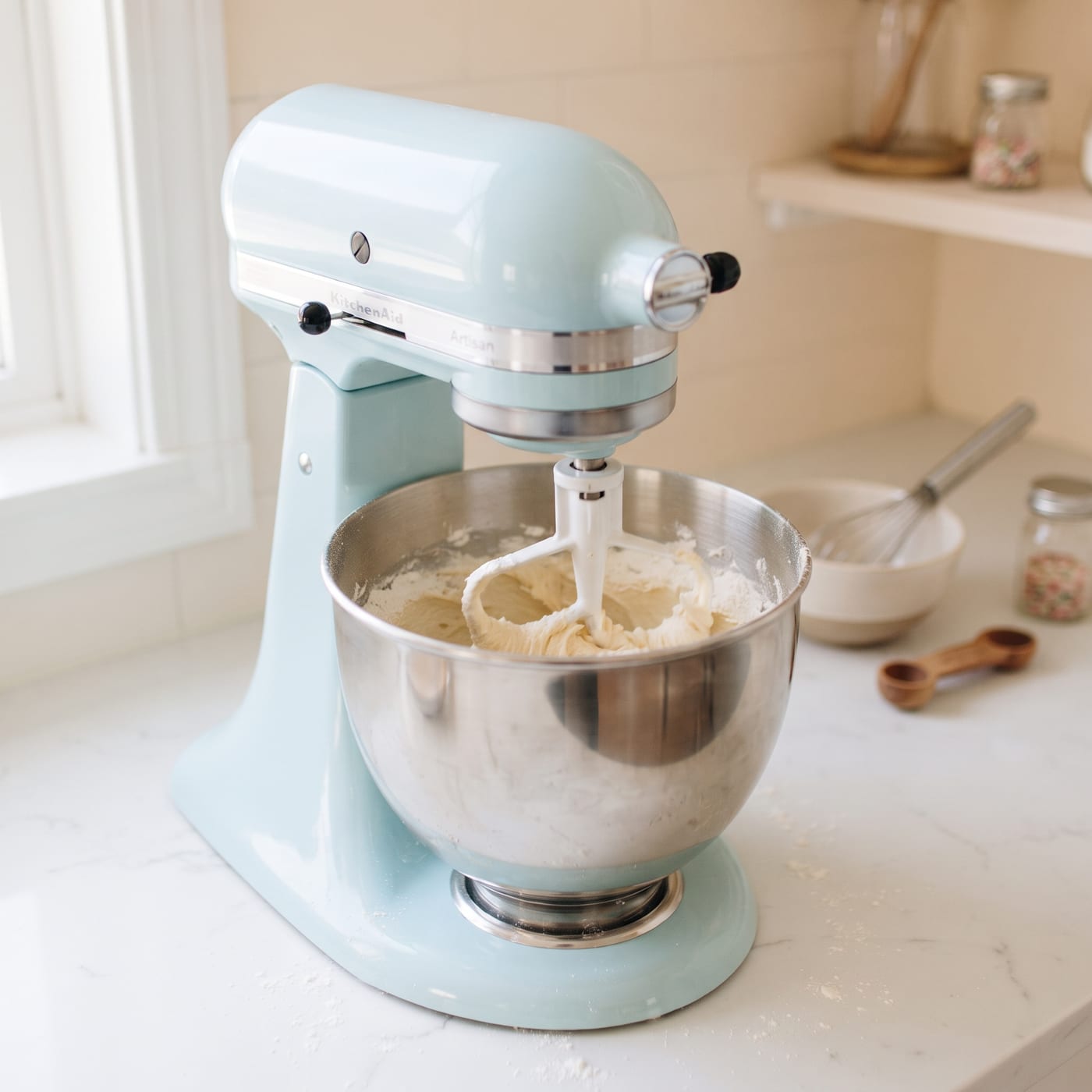 Stand mixer beating cupcake batter on low speed with flour streaks almost gone
