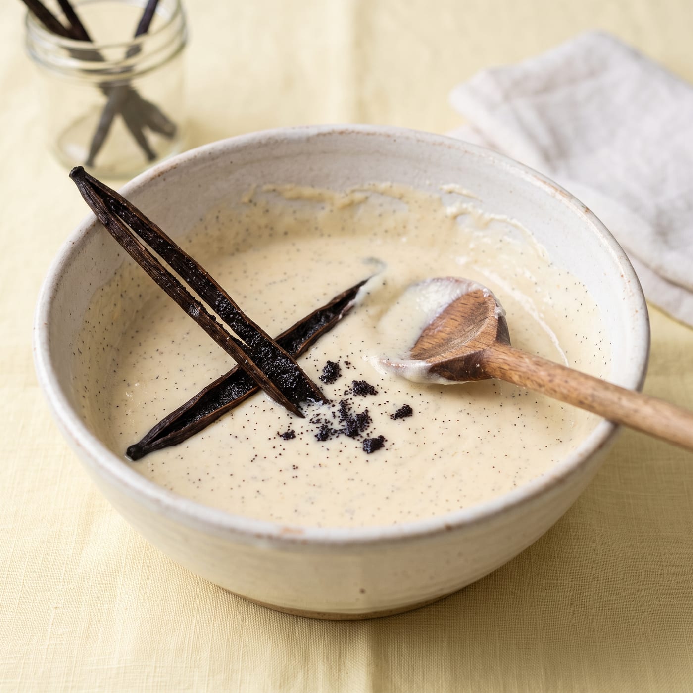 Vanilla bean seeds being scraped into cupcake batter in a mixing bowl