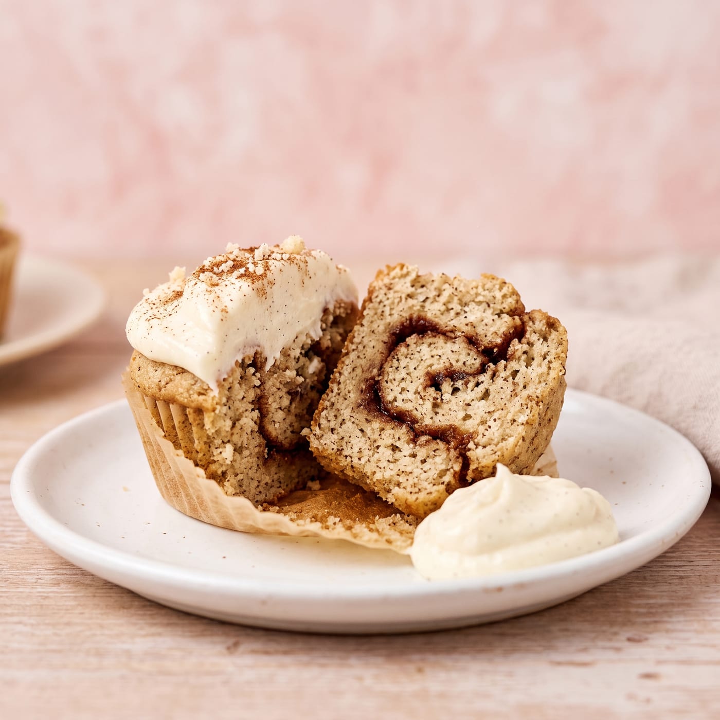 Close up cross section of a keto cinnamon roll cupcake showing the cinnamon swirl baked through the almond flour cake
