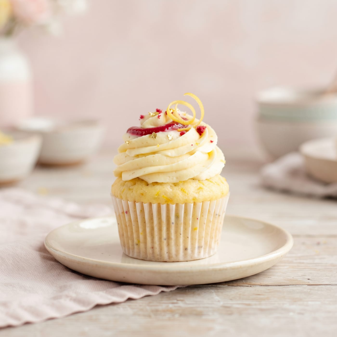Raspberry lemon cupcake with tall swirled frosting and a raspberry puree swirl on top
