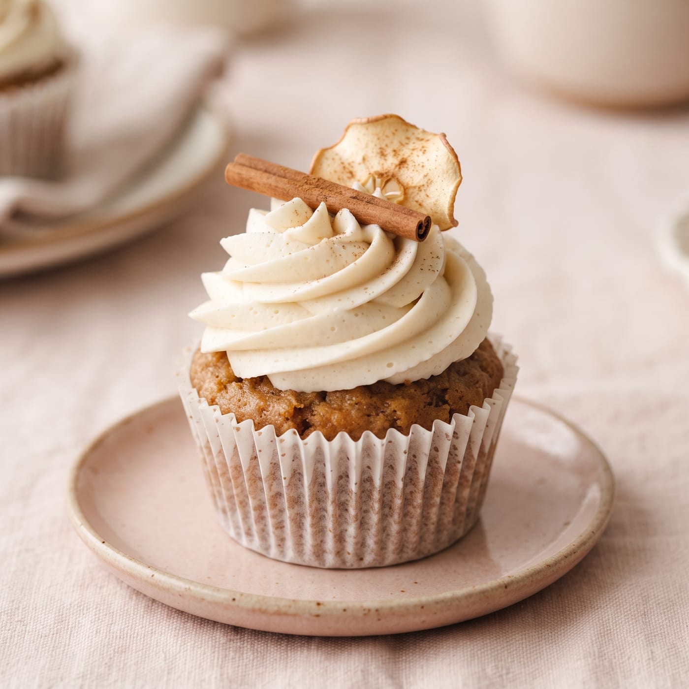 Close up of vegan cream swirl frosting on an apple spice cupcake showing texture