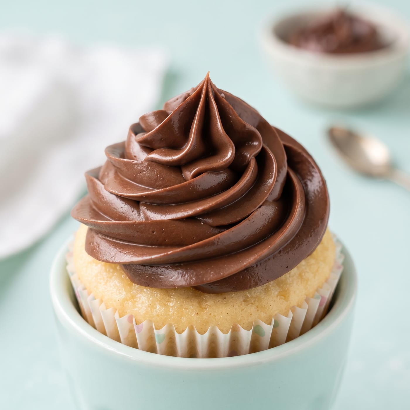Close up of silky chocolate frosting swirl showing smooth glossy texture
