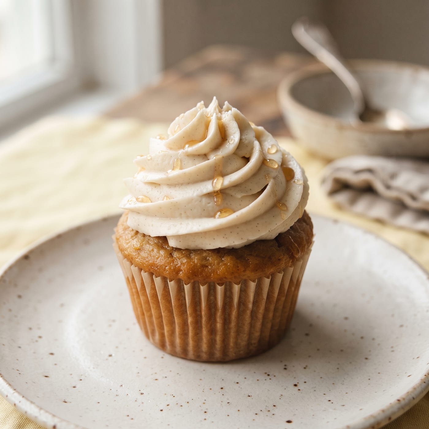 Close up of vegan cupcake frosting swirl with a light drizzle of agave syrup