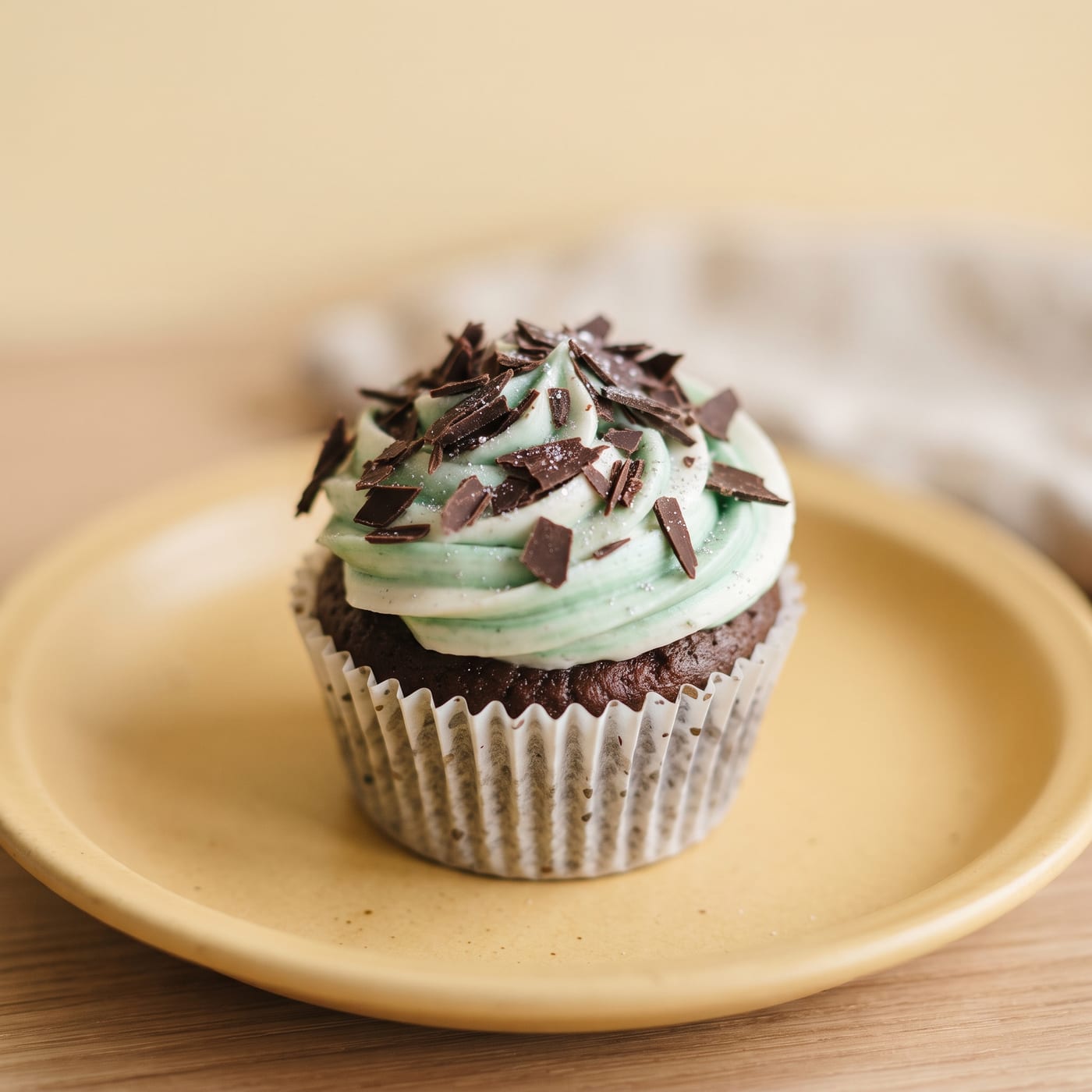 Close up of chocolate shavings resting on peppermint swirl frosting